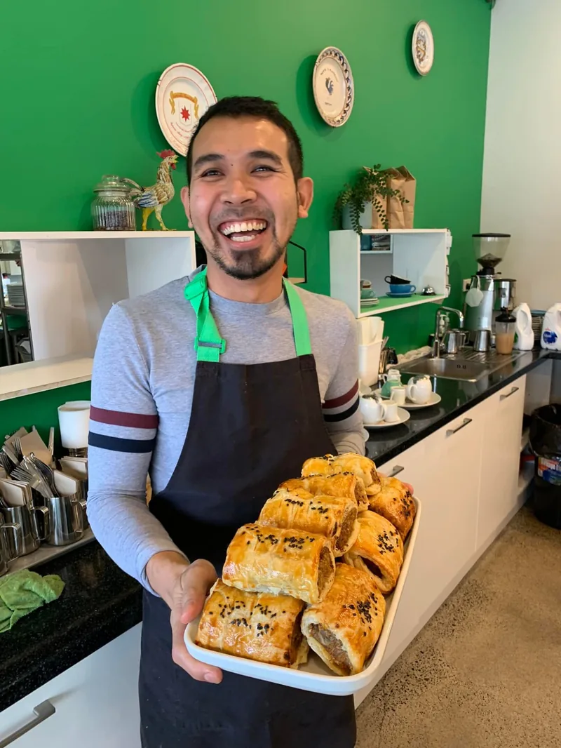 Mat holding pastries with a beaming smile